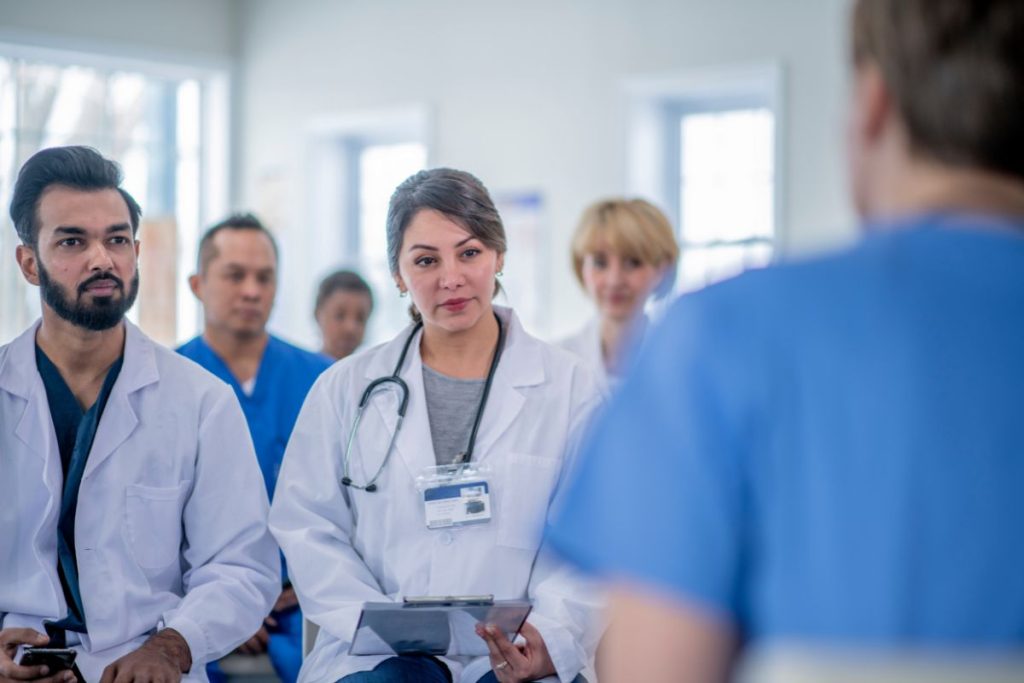 Gruppo di professionisti sanitari ascolta durante un incontro formativo